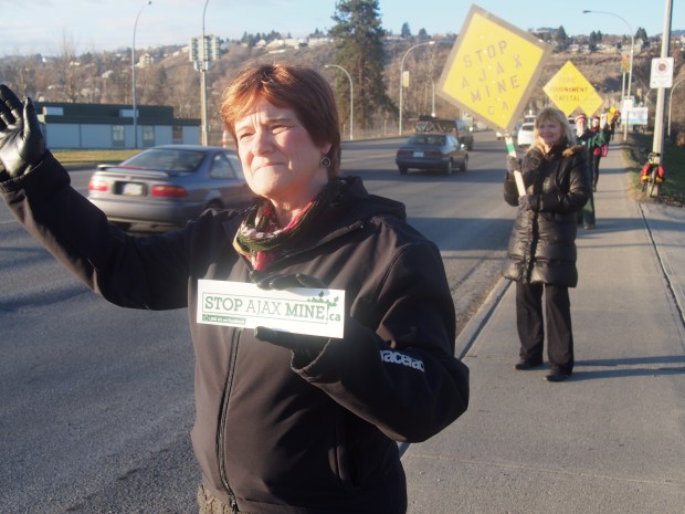 Ann-Marie Hunter waves to motorists on Overlanders Bridge Friday morning as part of a Stop Ajax Mine protest. Dianne Kerr, behind, and about 40 other protesters joined the demonstration.