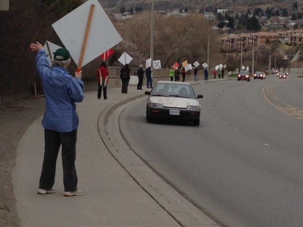 Anti-Ajax protesters wave to drivers on Columbia Street hill.