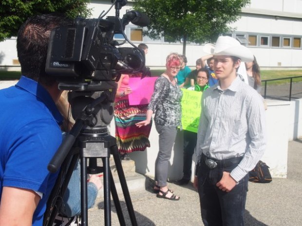 Beattie principal Barb Hamblett tells students who walked out of classes on Wednesday that they cannot protest on school property while student Brendan Stokes is interviewed by a TV crew.