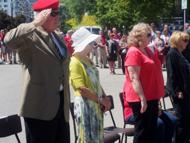 A retired armed forces officer salutes during the ceremony.