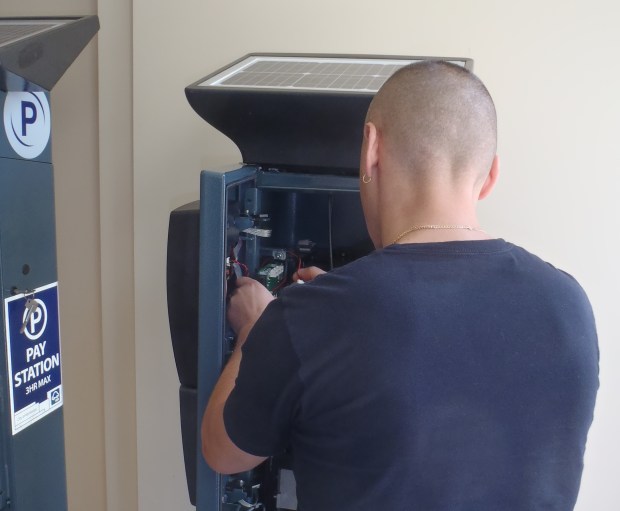 Technician installs new screen at demonstration kiosk.