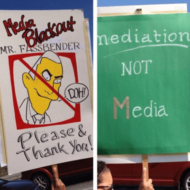 Signs at conference expressed teachers' unhappiness with what they said was education minister's violation of media blackout.