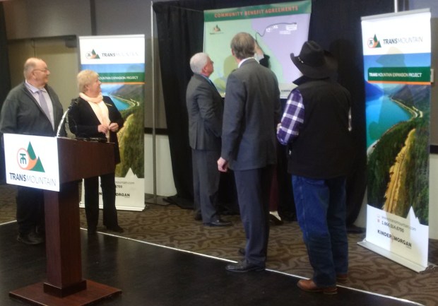 Dignitaries add community names to map showing where MOUs have been signed.