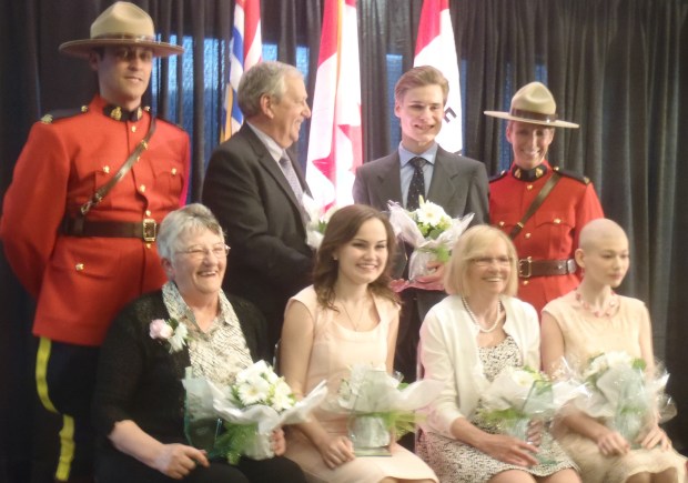 Distinguished Service Award volunteers shared a laugh after the ceremonies. Front row, from left, are Marg Rodgers, Julie Moray, Joan Wymer and Chenel Meunier-Tedford. Back row, between RCMP, are Bob Cowden and Jordan Popadynetz.